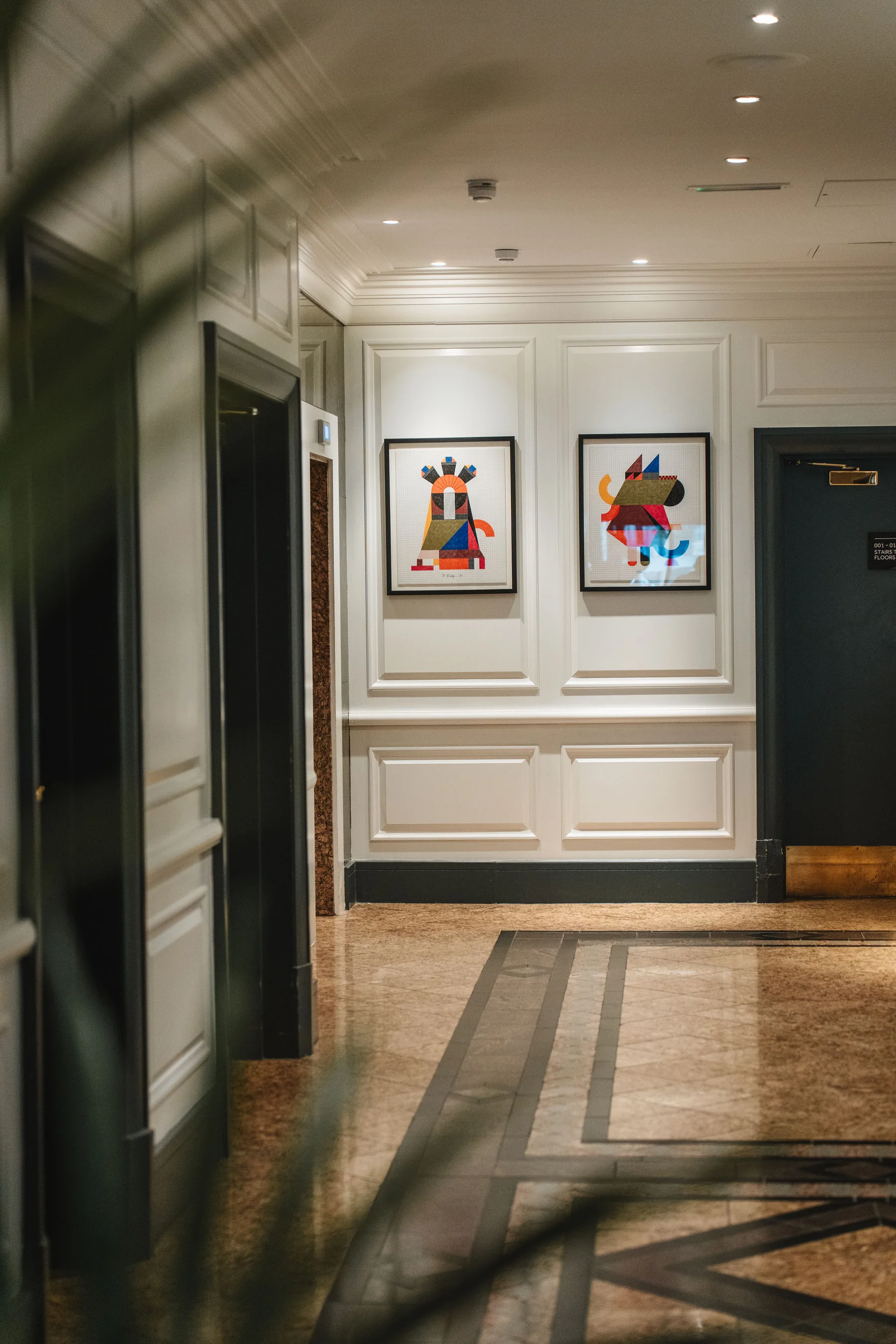 Elegante Hotellobby mit zeitgenössischer Kunst und warmen Steinoberflächen